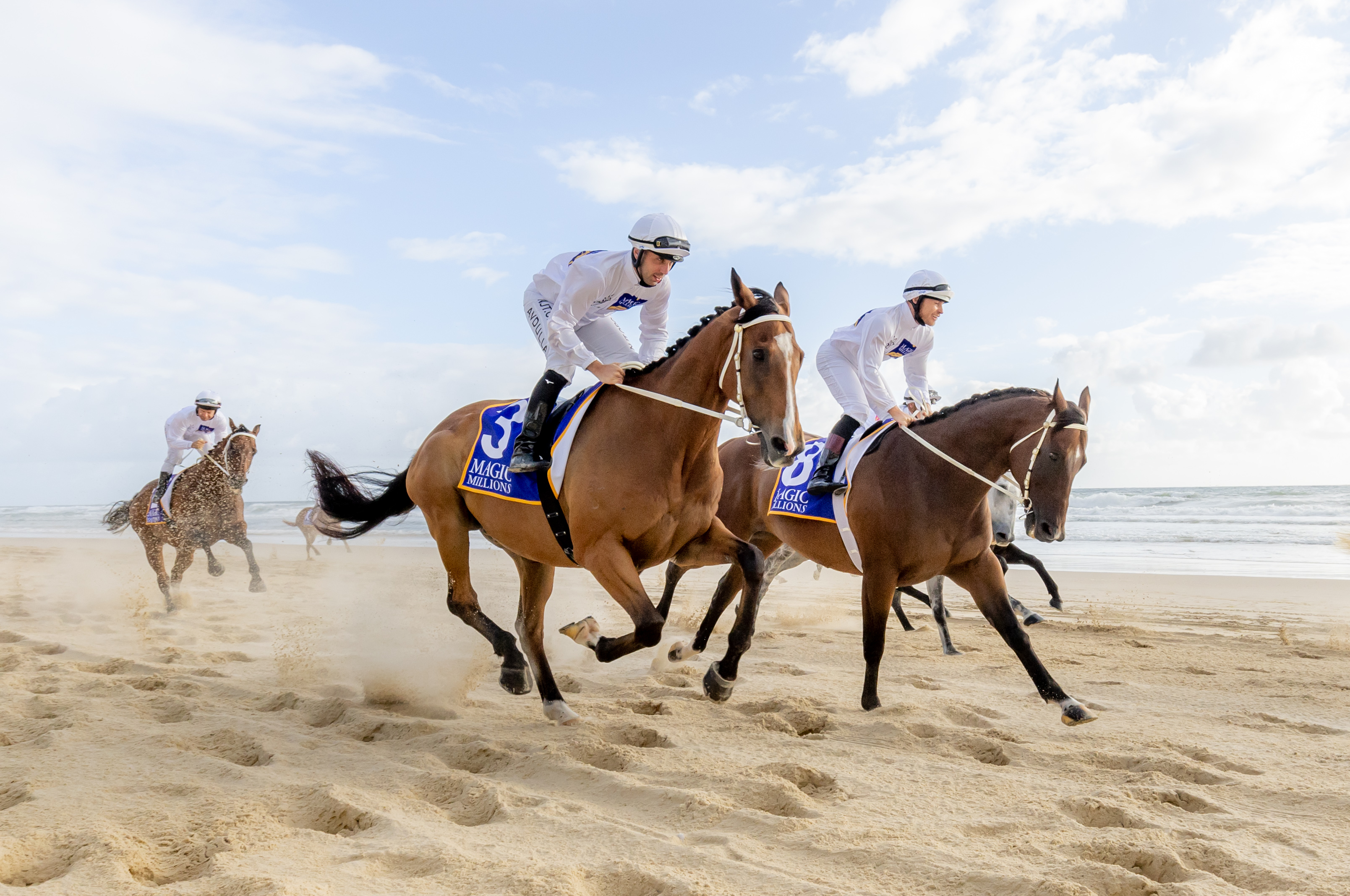 Jockeys riding their horses on Surfers Paradise beachfront  